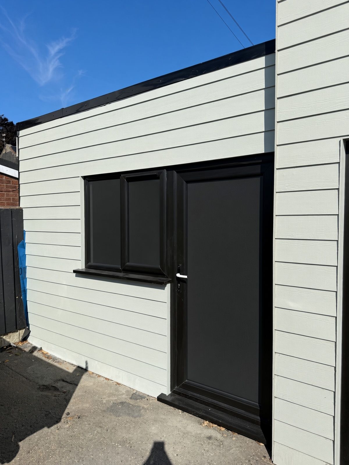 Black PVCu window and door fitted to sage green cladding on commercial extension in Gorleston, Norfolk