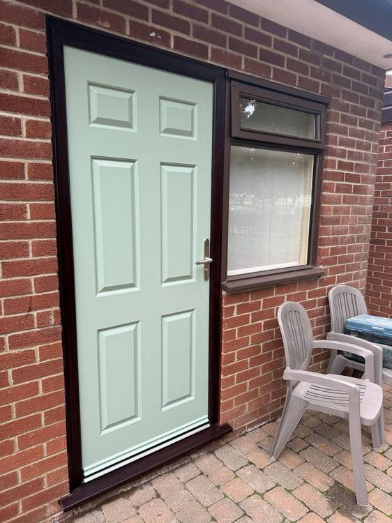 New Chartwell Green composite front door with rosewood PVCu frame fitted at Potters Leisure Resort Hopton-on-Sea Norfolk next to existing timber window – Prostar Windows composite door installation Great Yarmouth